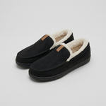Pair of black fleece-lined house loafers on a light-gray studio background